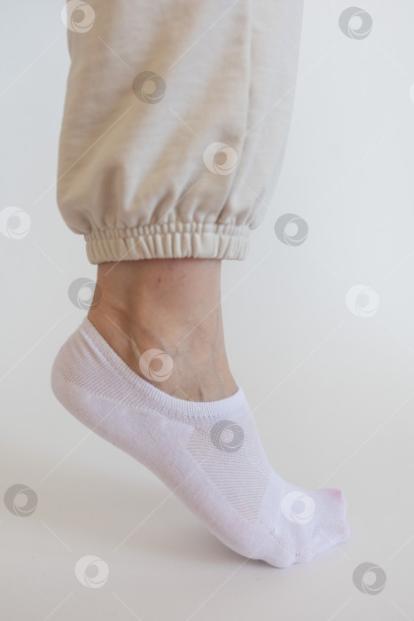 Скачать Женская ножка в белом носке на белом фоне фотосток Ozero