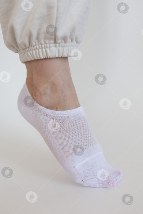 Скачать Женская ножка в белом носке на белом фоне фотосток Ozero