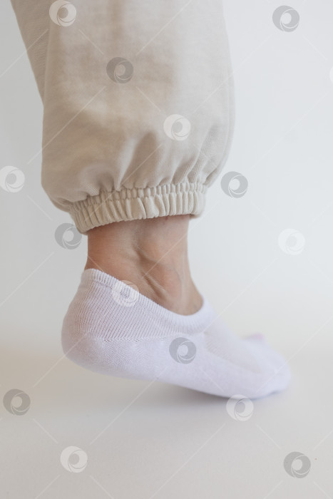 Скачать Женская ножка в белом носке на белом фоне фотосток Ozero