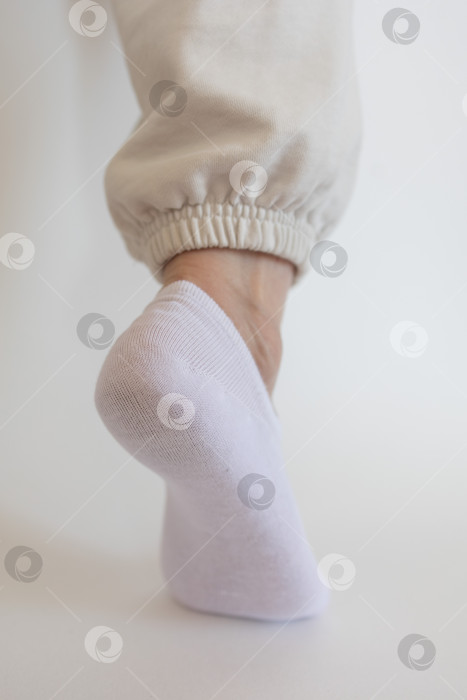 Скачать Женская ножка в белом носке на белом фоне фотосток Ozero