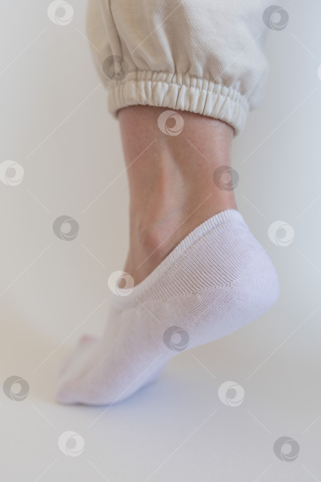Скачать Женская ножка в белом носке на белом фоне фотосток Ozero