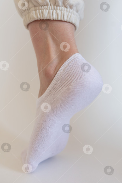 Скачать Женская ножка в белом носке на белом фоне фотосток Ozero