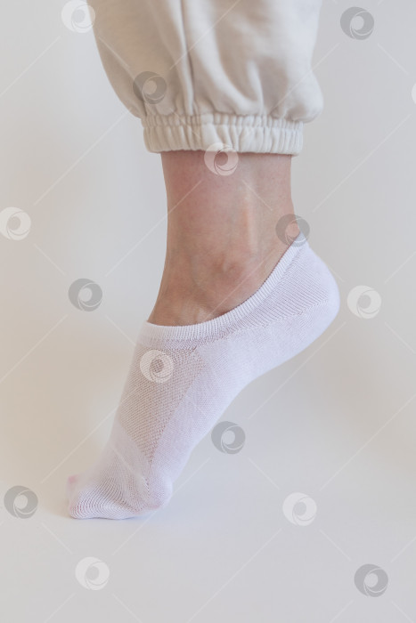 Скачать Женская ножка в белом носке на белом фоне фотосток Ozero
