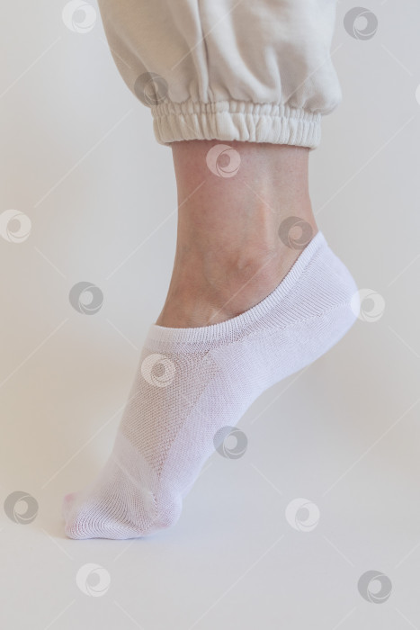 Скачать Женская ножка в белом носке на белом фоне фотосток Ozero