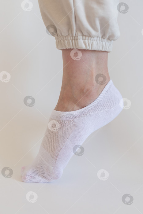 Скачать Женская ножка в белом носке на белом фоне фотосток Ozero