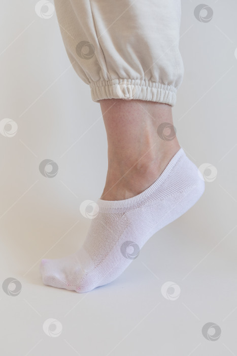 Скачать Женская ножка в белом носке на белом фоне фотосток Ozero