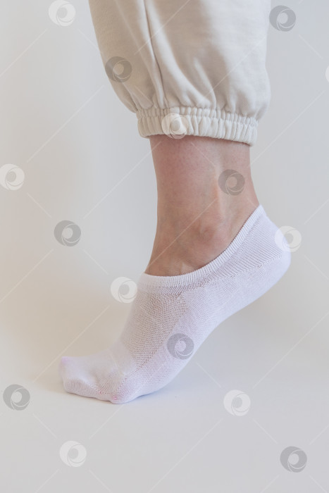 Скачать Женская ножка в белом носке на белом фоне фотосток Ozero