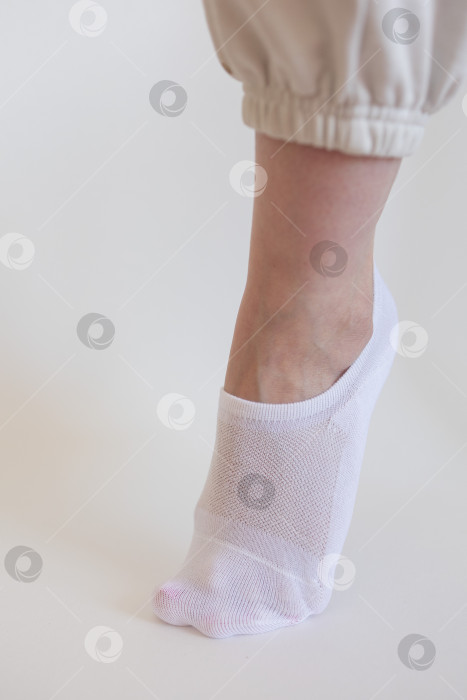 Скачать Женская ножка в белом носке на белом фоне фотосток Ozero