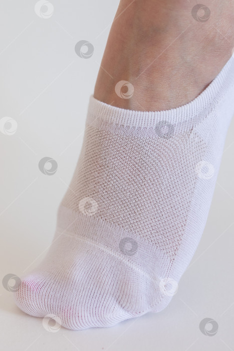 Скачать Женская ножка в белом носке на белом фоне фотосток Ozero