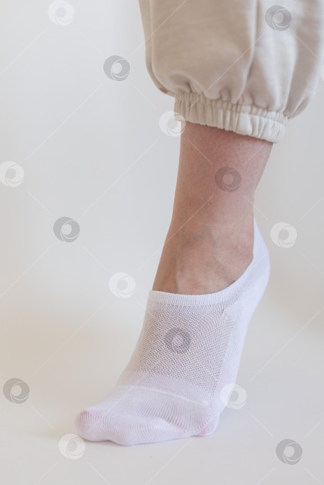 Скачать Женская ножка в белом носке на белом фоне фотосток Ozero