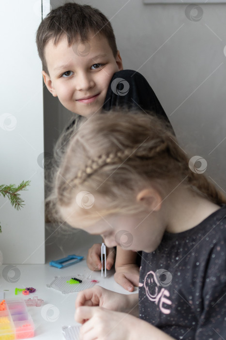 Скачать Дети играют в аквамозайку.Мальчик и девочка.Новогодние каникулы. Новогодние развлечения для детей фотосток Ozero