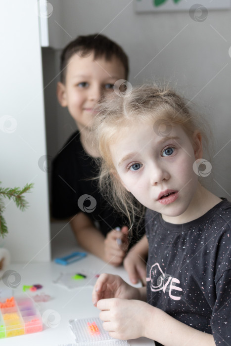 Скачать Дети играют в аквамозайку.Мальчик и девочка.Новогодние каникулы. Новогодние развлечения для детей фотосток Ozero