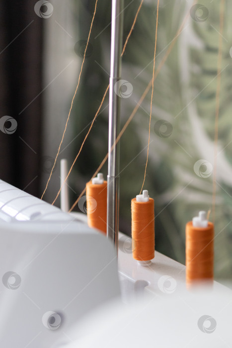 Скачать оранжевые нитки на швейной машине. Наматывание ниток на шпульку фотосток Ozero