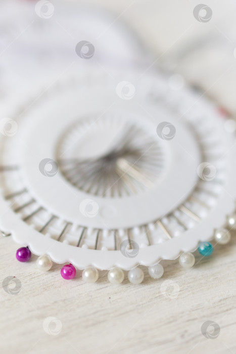 Скачать Закрепляющие булавки на ткани. белый фон фотосток Ozero