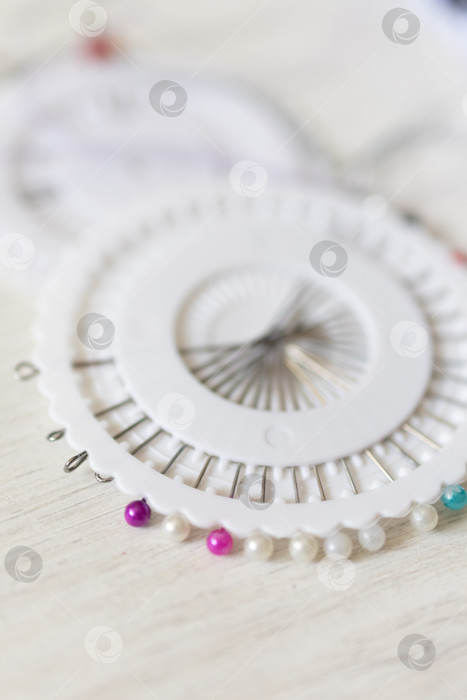 Скачать Закрепляющие булавки на ткани. белый фон фотосток Ozero