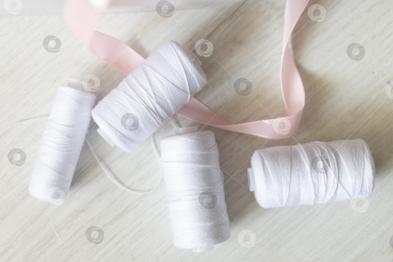 Скачать Белые швейные нитки. белый фон фотосток Ozero