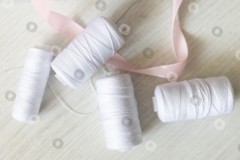 Скачать Белые швейные нитки. белый фон фотосток Ozero