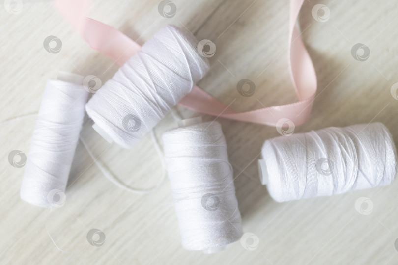 Скачать Белые швейные нитки. белый фон фотосток Ozero