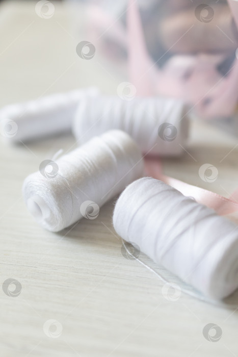 Скачать Белые швейные нитки. белый фон фотосток Ozero