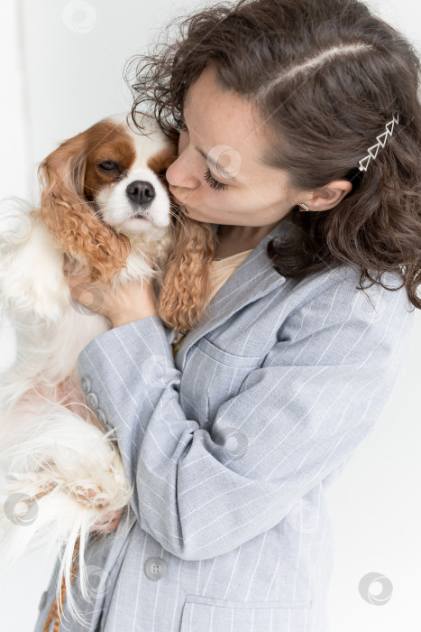 Скачать женщина целует собаку, кавалер Кинг Чарльз спаниеля. Молодая женщина целует свою собаку фотосток Ozero