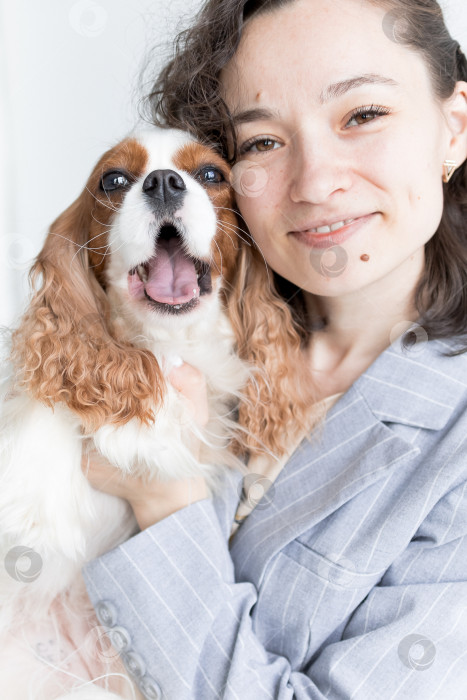 Скачать женщина держит на руках кинг Чарльз спаниеля фотосток Ozero