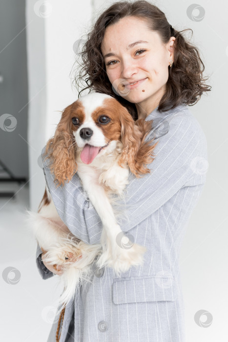 Скачать женщина держит на руках кинг Чарльз спаниеля фотосток Ozero