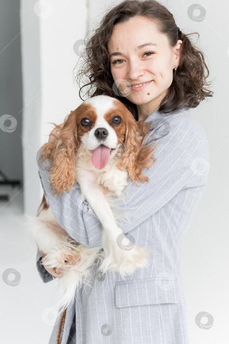 Скачать женщина держит на руках кинг Чарльз спаниеля фотосток Ozero