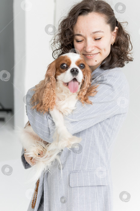 Скачать женщина держит на руках кинг Чарльз спаниеля фотосток Ozero