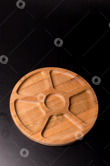 Скачать Пустая круглая минажница из дерева на черном фоне фотосток Ozero