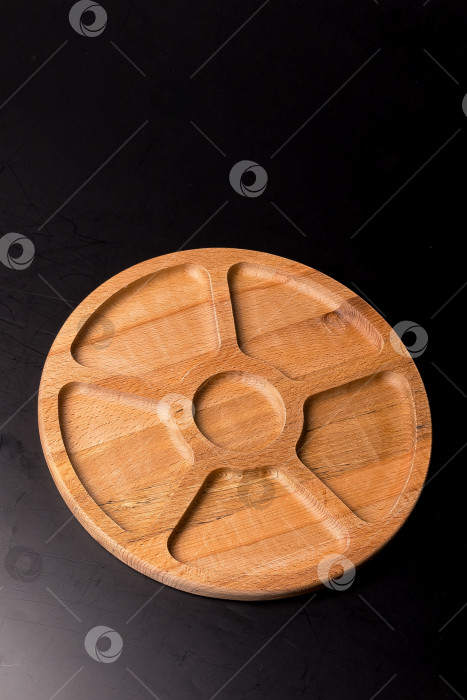 Скачать Пустая круглая минажница из дерева на черном фоне фотосток Ozero