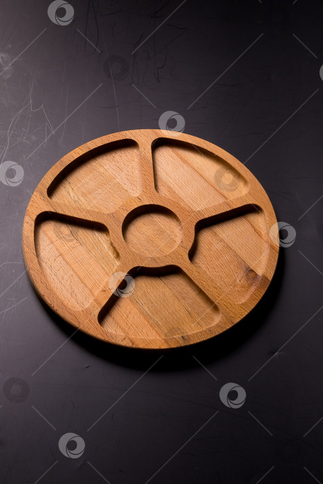 Скачать Пустая круглая минажница из дерева на черном фоне фотосток Ozero