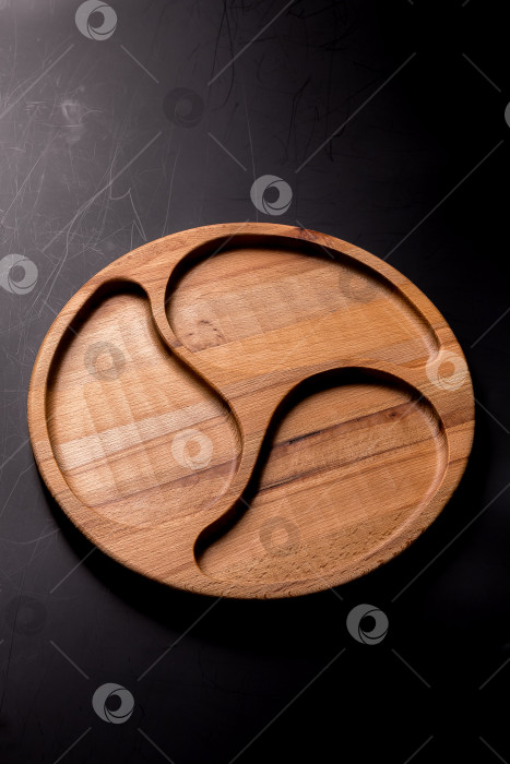 Скачать Пустая круглая минажница из дерева на черном фоне фотосток Ozero