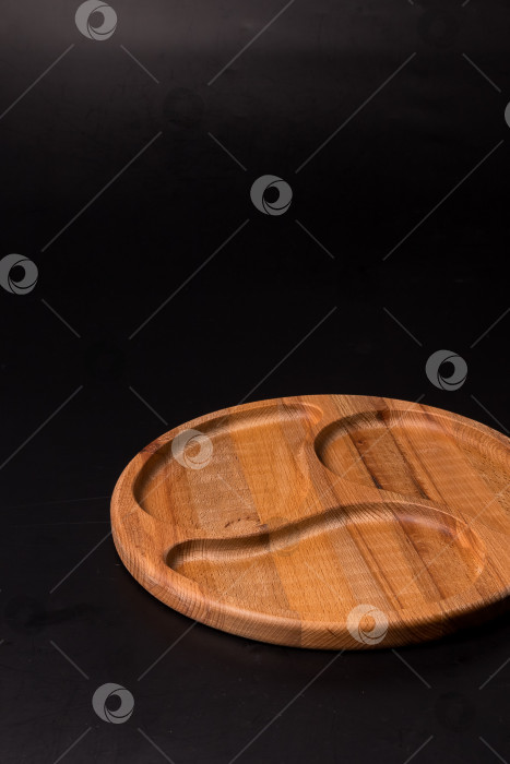 Скачать Пустая круглая минажница из дерева на черном фоне фотосток Ozero