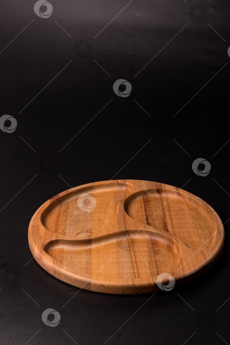 Скачать Пустая круглая минажница из дерева на черном фоне фотосток Ozero