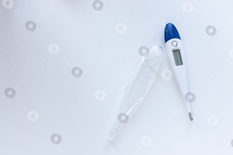 Скачать Электрический термометр не показывает температуру. термометр в футляре на белом фоне. место для текста фотосток Ozero