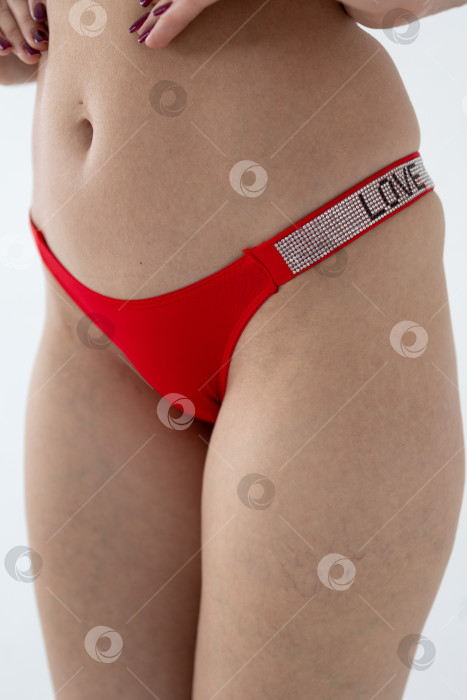 Скачать На модели красные женские трусы. тело молодой женщины в красных трусиках-стрингах фотосток Ozero