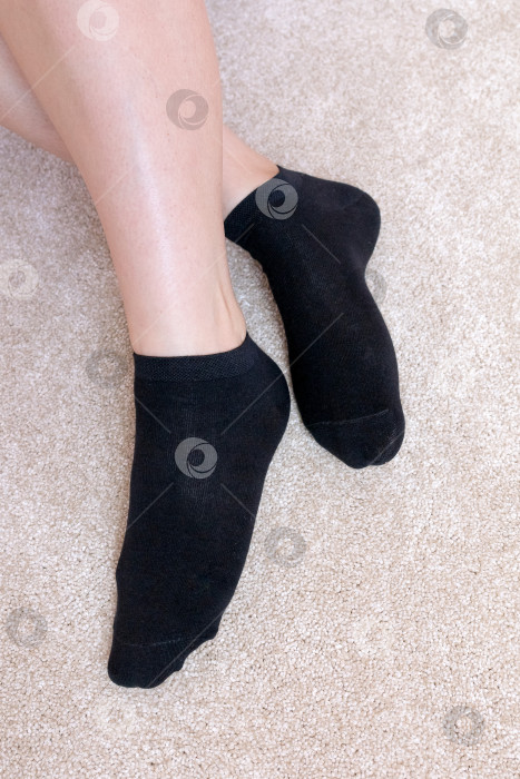 Скачать Женские ножки в черных носках на ковре фотосток Ozero