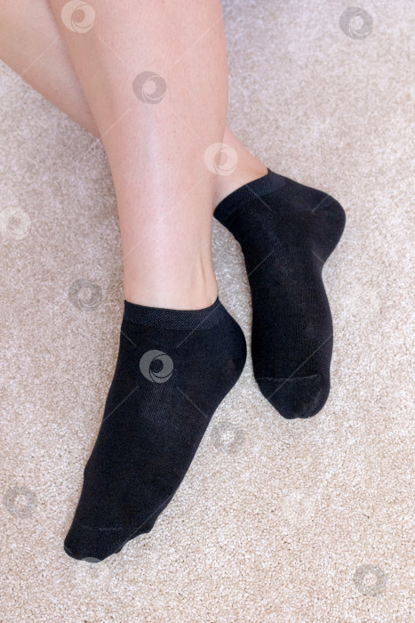 Скачать Женские ножки в черных носках на ковре фотосток Ozero