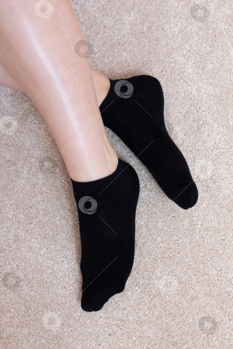 Скачать Женские ножки в черных носках на ковре фотосток Ozero