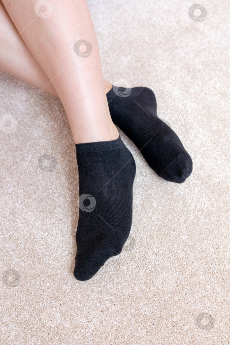 Скачать Женские ножки в черных носках на ковре фотосток Ozero