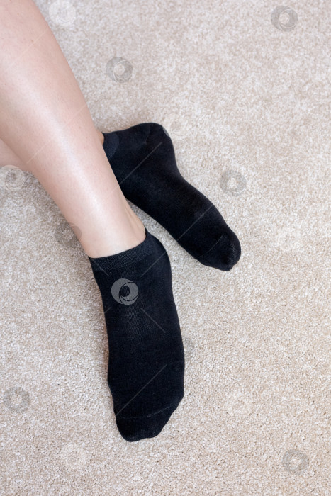 Скачать Женские ножки в черных носках на ковре фотосток Ozero