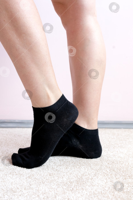 Скачать Женские ножки в черных носках на ковре фотосток Ozero