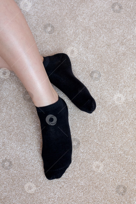 Скачать Женские ножки в черных носках на ковре фотосток Ozero