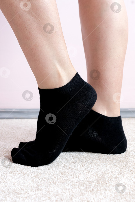 Скачать Женские ножки в черных носках на ковре фотосток Ozero