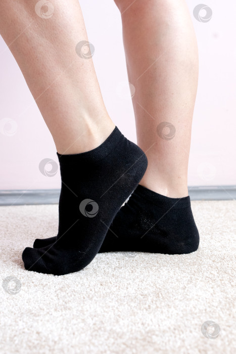 Скачать Женские ножки в черных носках на ковре фотосток Ozero
