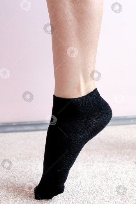 Скачать Женские ножки в черных носках на ковре фотосток Ozero