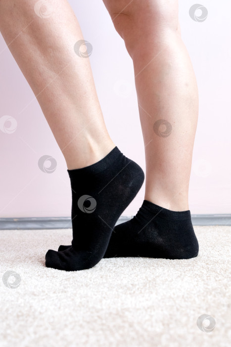 Скачать Женские ножки в черных носках на ковре фотосток Ozero