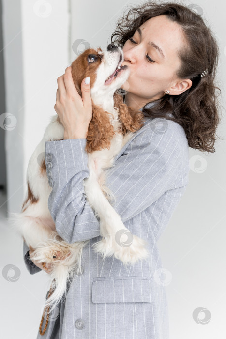 Скачать женщина целует собаку, кавалер Кинг Чарльз спаниеля. Молодая женщина целует свою собаку фотосток Ozero