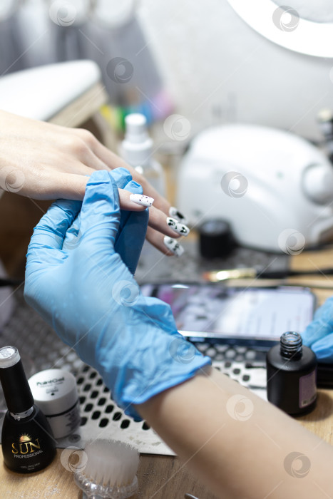 Скачать Мастер маникюра делает маникюр клиенту в салоне красоты. Neil care. Закрыть фотосток Ozero