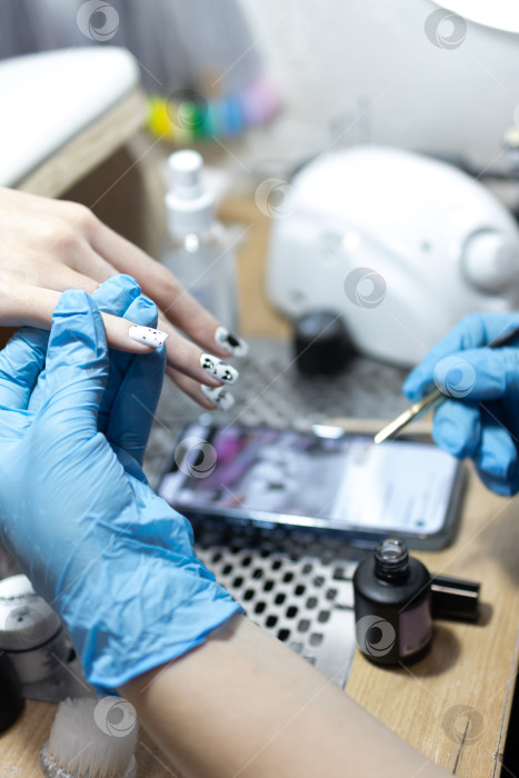 Скачать Мастер маникюра делает маникюр клиенту в салоне красоты. Neil care. Закрыть фотосток Ozero